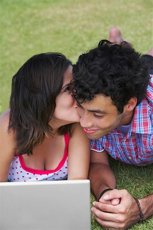 Close-up of a young couple lying in a lawn in front of a laptop Stock Photo - Premium Royalty-Free, Code: 625-01746757