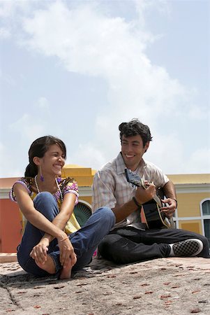 simsearch:625-01746515,k - Young man sitting with a young woman and playing a guitar Fotografie stock - Premium Royalty-Free, Codice: 625-01746783