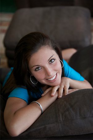 Portrait of a young woman lying on a couch and smiling Stock Photo - Premium Royalty-Free, Code: 625-01746791