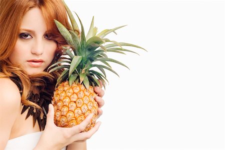 single pineapple - Portrait of a young woman holding a pineapple Stock Photo - Premium Royalty-Free, Code: 625-01746823