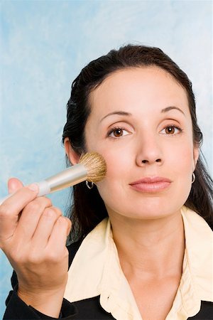 simsearch:625-02932995,k - Portrait of a businesswoman applying make-up on her face with a make-up brush Stock Photo - Premium Royalty-Free, Code: 625-01746877