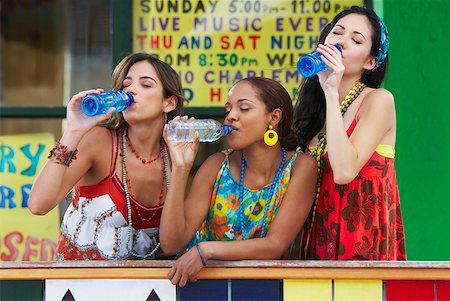 simsearch:625-01746733,k - Trois jeunes femmes accoudée à une balustrade et de boire l'eau des bouteilles Photographie de stock - Premium Libres de Droits, Code: 625-01746900