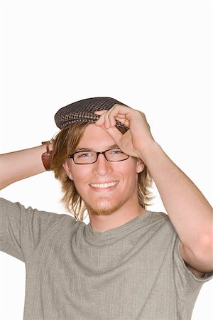 simsearch:625-01746920,k - Portrait of a young man adjusting his flat cap and smiling Foto de stock - Sin royalties Premium, Código: 625-01746920