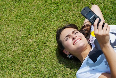 simsearch:625-00902766,k - High angle view of a young woman text messaging and smiling Foto de stock - Sin royalties Premium, Código: 625-01746990