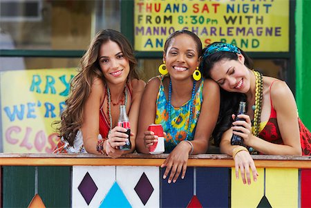 Portrait of three young women leaning on a railing and holding cold drinks Stock Photo - Premium Royalty-Free, Code: 625-01747008