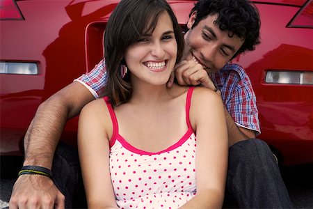 Close-up of a young couple sitting in front of a car Stock Photo - Premium Royalty-Free, Code: 625-01747072