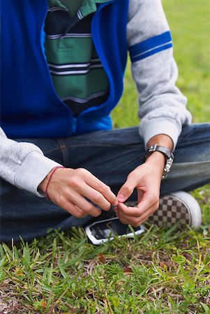 simsearch:625-01097247,k - Low section view of a teenage boy sitting in a park Stock Photo - Premium Royalty-Free, Code: 625-01747092