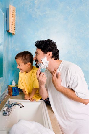 father and son and shave - Side profile of a mid adult man shaving with his son sitting beside him in the bathroom Stock Photo - Premium Royalty-Free, Code: 625-01747272