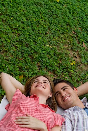 simsearch:625-01746733,k - Vue grand angle sur un jeune couple se trouvant dans un parc et souriant Photographie de stock - Premium Libres de Droits, Code: 625-01747394