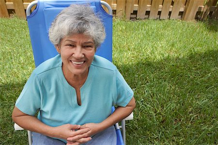 Portrait of a senior woman sitting in a lawn chair and smiling Stock Photo - Premium Royalty-Free, Code: 625-01747439