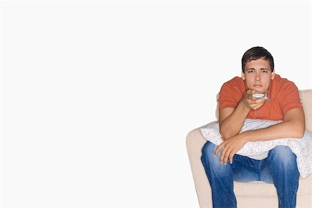 single man on the couch watching tv - Portrait of a young man sitting on a couch and watching television Stock Photo - Premium Royalty-Free, Code: 625-01747470