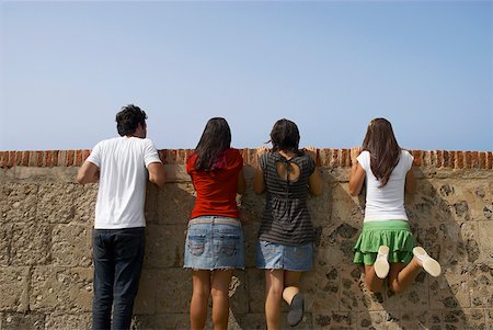 Vue arrière de trois jeunes femmes et un jeune homme regardant par dessus un mur de Pierre, Morro Castle, le vieux San Juan, San Juan, Puerto Rico Photographie de stock - Premium Libres de Droits, Code: 625-01747472