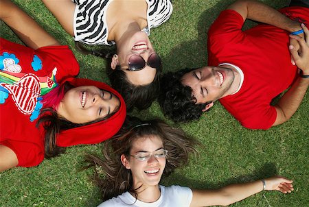 simsearch:625-01746602,k - Trois jeunes femmes avec un jeune homme couché sur l'herbe et souriant Photographie de stock - Premium Libres de Droits, Code: 625-01747521