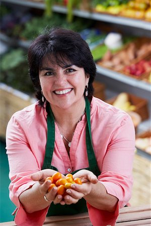 Portrait of a mature woman showing fruits and smiling Stock Photo - Premium Royalty-Free, Code: 625-01747532