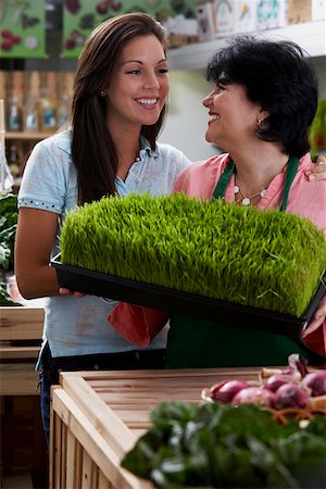 Mature woman and her daughter standing with a tray of wheatgrass in a grocery store and smiling Foto de stock - Sin royalties Premium, Código: 625-01747577