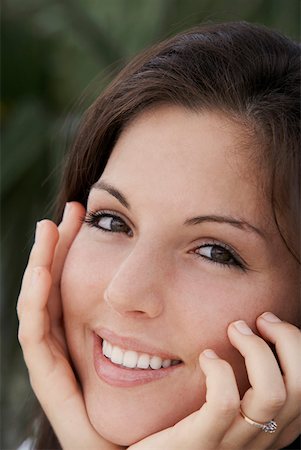 simsearch:625-01746920,k - Portrait of a young woman smiling with her hands on her chin Foto de stock - Sin royalties Premium, Código: 625-01747598