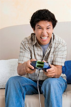 simsearch:625-01746391,k - Close-up of a young man playing video game and smiling Foto de stock - Sin royalties Premium, Código: 625-01747590