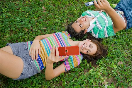 simsearch:625-01746733,k - Vue grand angle sur un jeune couple se trouvant dans le parc et tenir un téléphone mobile Photographie de stock - Premium Libres de Droits, Code: 625-01747675