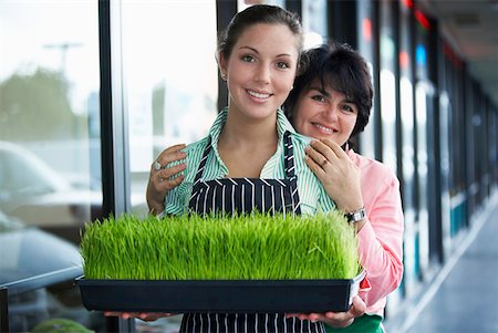 student latino business casual - Portrait of a young woman and her mother standing with a tray of wheatgrass and smiling Stock Photo - Premium Royalty-Free, Code: 625-01747759