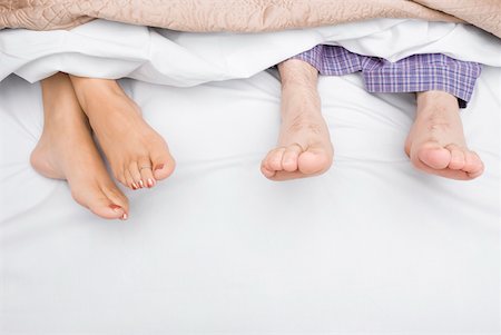 Close-up of a couple's feet on the bed Stock Photo - Premium Royalty-Free, Code: 625-01747862