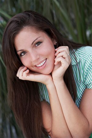 simsearch:625-01748942,k - Portrait of a young woman smiling with her hands on her chin Foto de stock - Sin royalties Premium, Código: 625-01747896