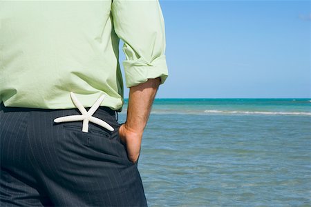 estrella de mar - Mid section view of a man standing on the beach with his hands in his pockets Foto de stock - Sin royalties Premium, Código: 625-01748046