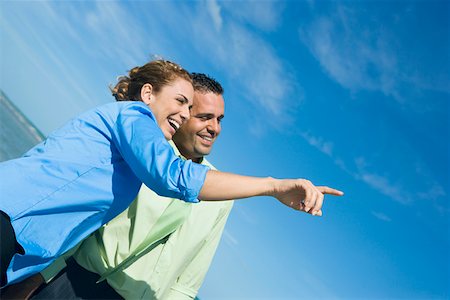 Side profile of a mid adult woman pointing with a mid adult man standing beside her Stock Photo - Premium Royalty-Free, Code: 625-01748054