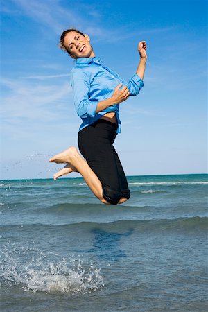 Side profile of a mid adult woman jumping on the beach Stock Photo - Premium Royalty-Free, Code: 625-01748064