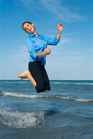 Side profile of a mid adult woman jumping on the beach Stock Photo - Premium Royalty-Free, Code: 625-01748071