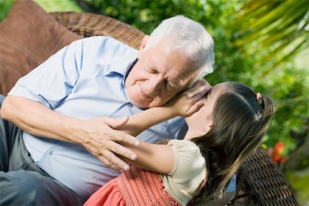 Girl whispering into her grandfather's ear Stock Photo - Premium Royalty-Free, Code: 625-01748154