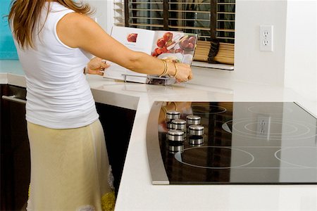 Mature woman reading a cookbook at a kitchen counter Foto de stock - Sin royalties Premium, Código: 625-01748159