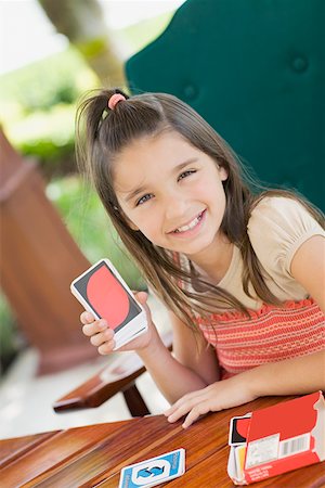 playing cards table - Portrait of a girl showing playing cards and smiling Stock Photo - Premium Royalty-Free, Code: 625-01748203