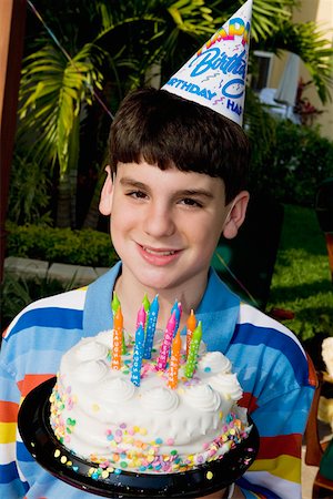 simsearch:625-01753509,k - Portrait d'un garçon tenant un gâteau d'anniversaire et souriant Photographie de stock - Premium Libres de Droits, Code: 625-01748237