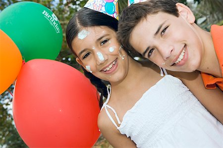 simsearch:625-01748263,k - Portrait of a boy and his sister wearing birthday hats and smiling Stock Photo - Premium Royalty-Free, Code: 625-01748249