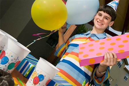 simsearch:625-01748263,k - Portrait of a boy holding a birthday present and balloons Stock Photo - Premium Royalty-Free, Code: 625-01748241