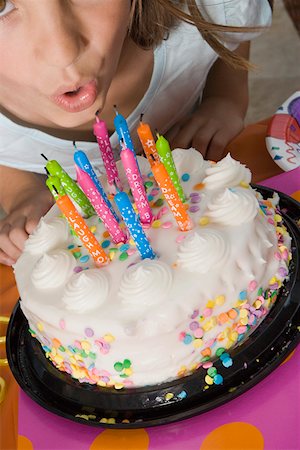 High angle view of a girl blowing candles on her birthday cake Stock Photo - Premium Royalty-Free, Code: 625-01748250