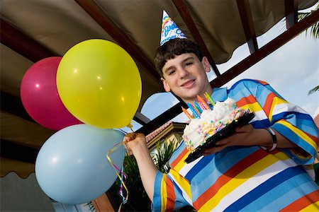 simsearch:625-01748263,k - Portrait of a boy holding a birthday cake and balloons Stock Photo - Premium Royalty-Free, Code: 625-01748266