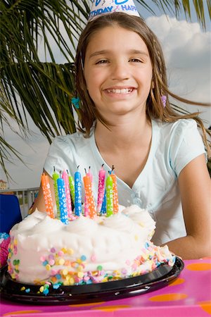 simsearch:625-01748263,k - Portrait of a girl smiling in front of a birthday cake Stock Photo - Premium Royalty-Free, Code: 625-01748269