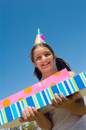 simsearch:625-01748263,k - Portrait of a girl holding birthday presents and smiling Stock Photo - Premium Royalty-Free, Code: 625-01748260