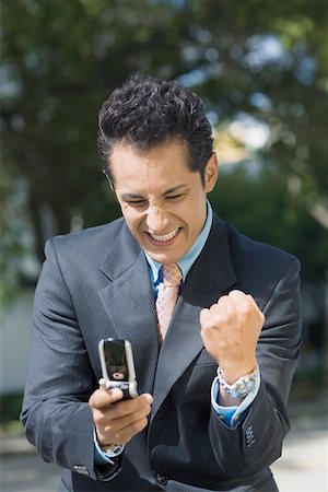 simsearch:625-01096675,k - Close-up of a businessman looking at a mobile phone and making a fist Stock Photo - Premium Royalty-Free, Code: 625-01748378