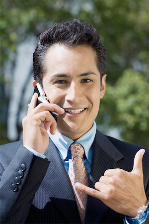 simsearch:625-02266709,k - Portrait of a businessman talking on a mobile phone and showing call me gesture Foto de stock - Sin royalties Premium, Código: 625-01748387
