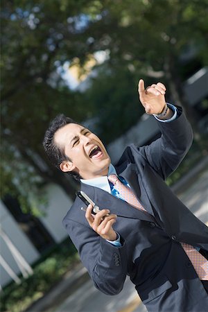 eye pointing - Businessman holding a mobile phone and shouting Stock Photo - Premium Royalty-Free, Code: 625-01748396