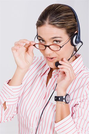 simsearch:625-01748576,k - Portrait of a businesswoman adjusting her eyeglasses and a headset Foto de stock - Royalty Free Premium, Número: 625-01748409
