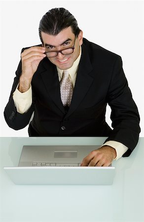 simsearch:625-01096766,k - Portrait of a businessman using a laptop and smiling Stock Photo - Premium Royalty-Free, Code: 625-01748410