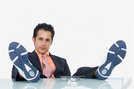 Portrait of a businessman resting with his feet up in an office Stock Photo - Premium Royalty-Free, Code: 625-01748426