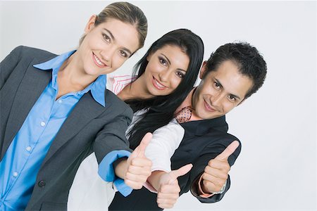 portrait of a group of clerks - Portrait of two businesswomen and a businessman standing in a row and making a thumbs up sign Stock Photo - Premium Royalty-Free, Code: 625-01748422