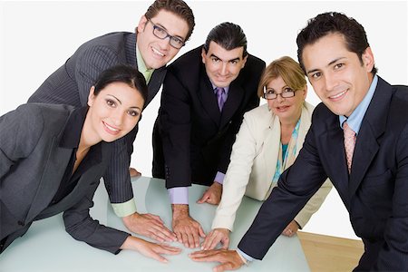 simsearch:625-02266585,k - Portrait of two businesswomen and three businessmen placing their hands on the table Fotografie stock - Premium Royalty-Free, Codice: 625-01748455