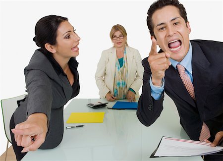 executive office profile - Side profile of a businesswoman pointing at another businessman standing in front of her Stock Photo - Premium Royalty-Free, Code: 625-01748459