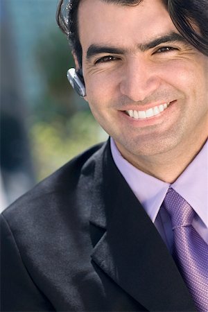 simsearch:625-01096675,k - Portrait of a businessman wearing a hands free device and smiling Stock Photo - Premium Royalty-Free, Code: 625-01748467