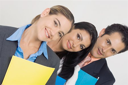 simsearch:625-02931286,k - Portrait of a businessman and two businesswomen smiling and holding files Stock Photo - Premium Royalty-Free, Code: 625-01748516